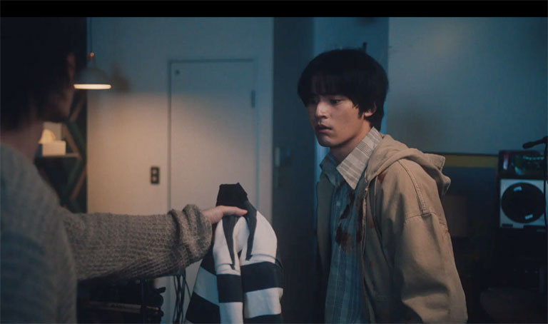 シイから「これを着て行け」と上着を手渡される都成